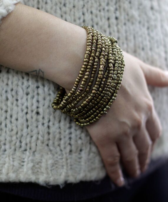 Náramek ze zlatých korálků.